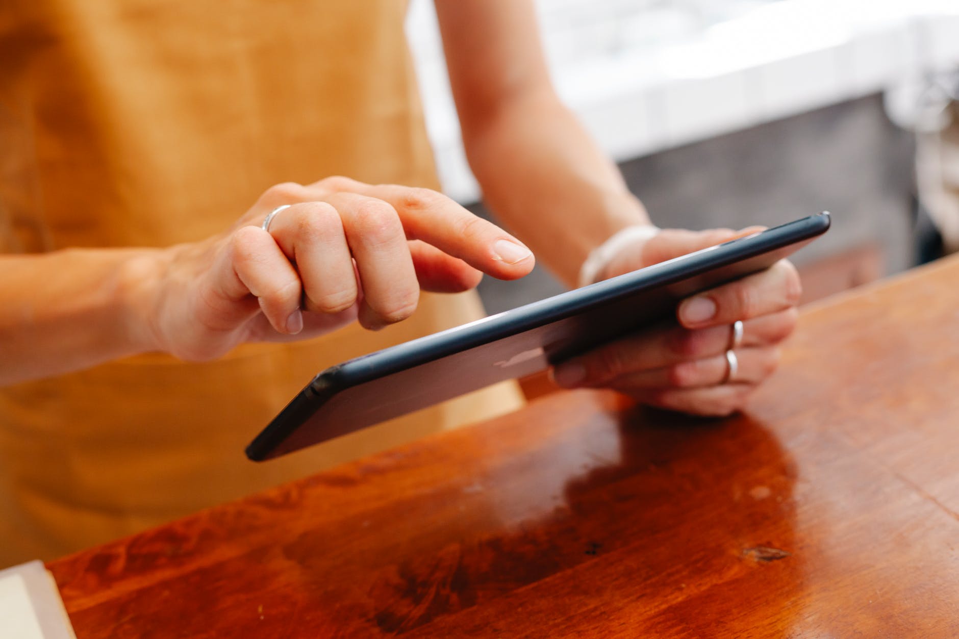 crop employee browsing internet on tablet at table